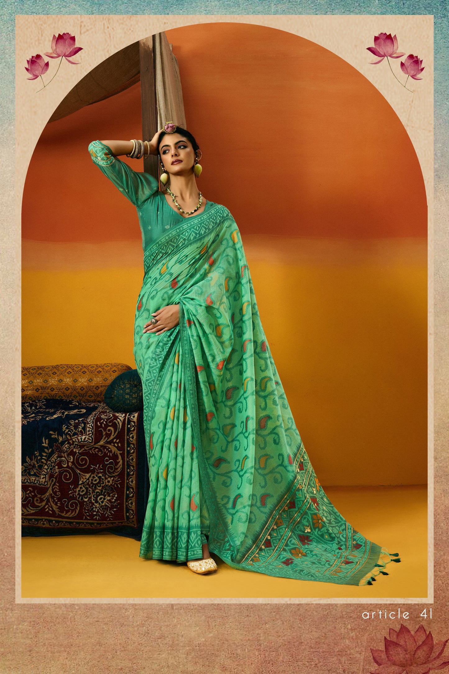 Woman in a green saree with floral patterns against a warm-toned background