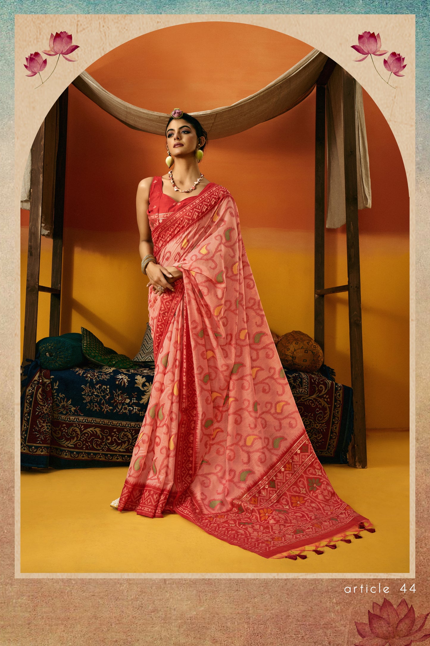 Woman in a pink saree standing in a decorated room with lotus flowers.