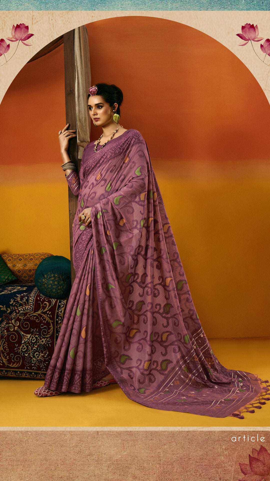Woman in a purple saree standing against an orange and blue gradient background with floral elements.