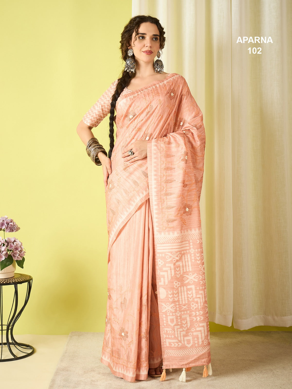 Elegant peach blush cotton blend saree featuring woven tribal pallu, printed design and soft lightweight fabric for daily ethnic wear