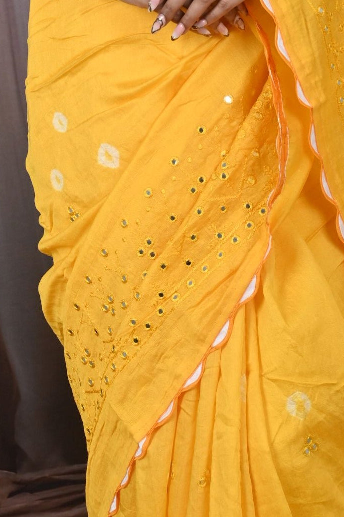 Woman in a yellow saree with a decorative background