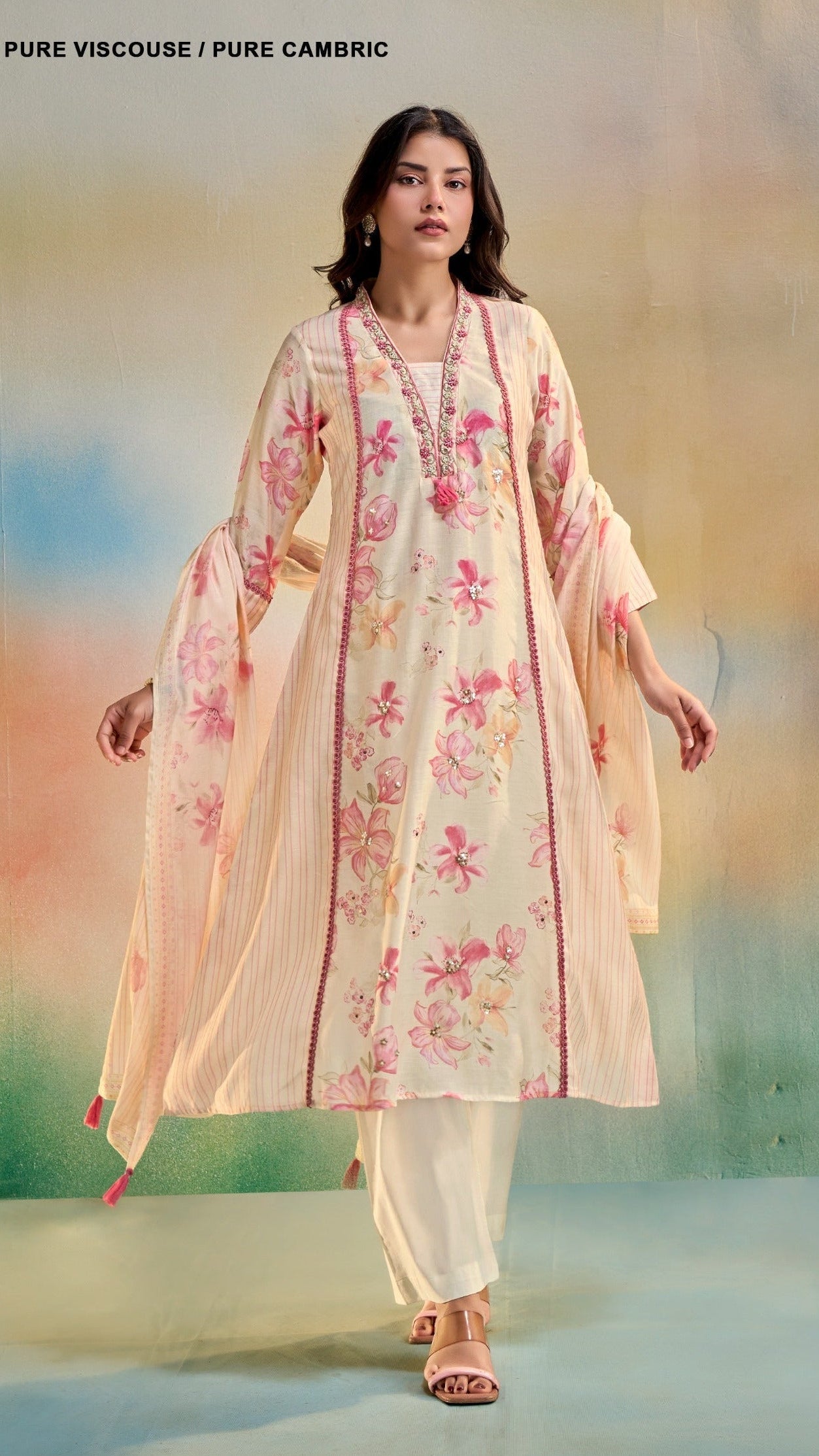 Woman wearing a floral kurta with a matching shawl against a blurred natural background