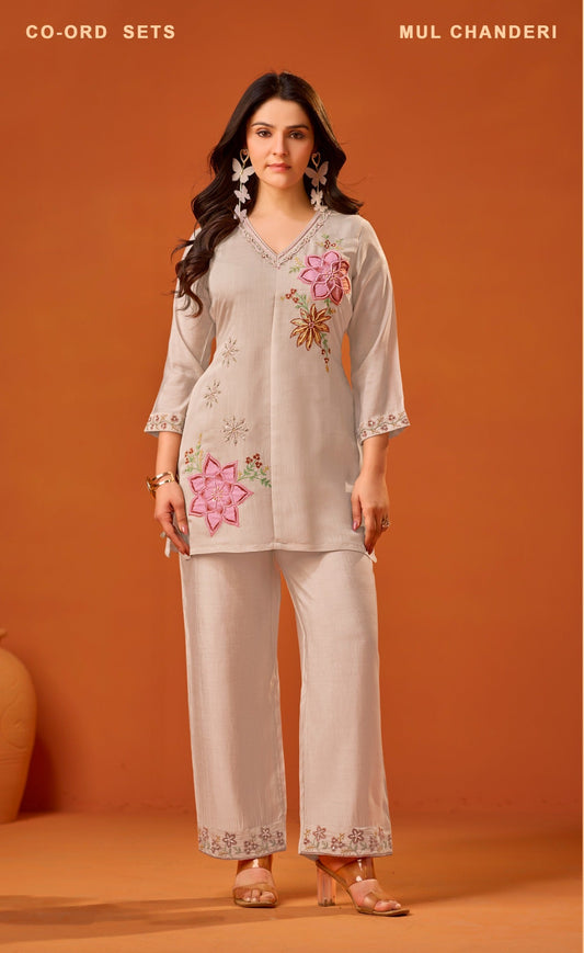 Woman wearing a beige embroidered outfit against an orange background