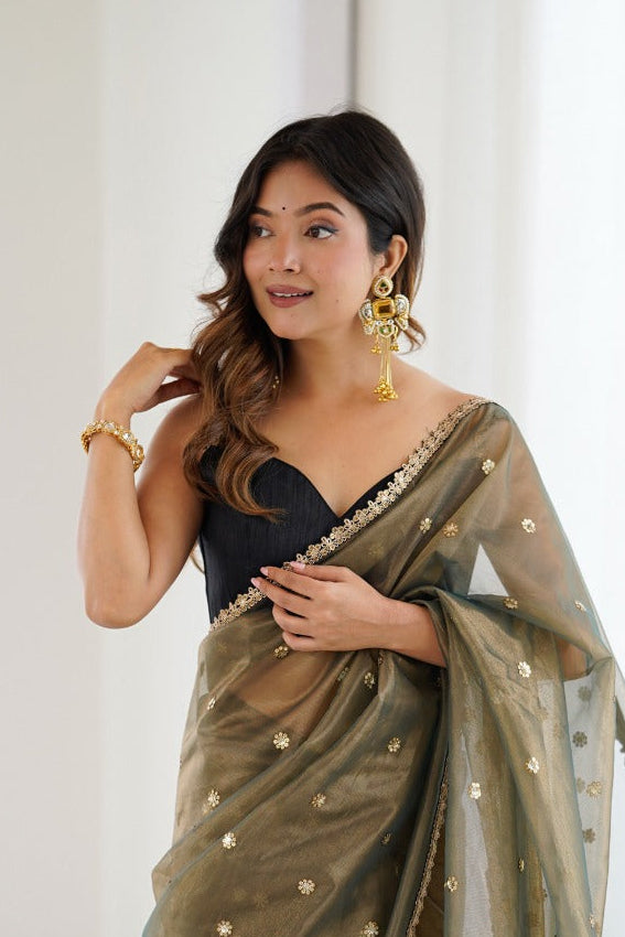 Woman wearing a green saree with a white background