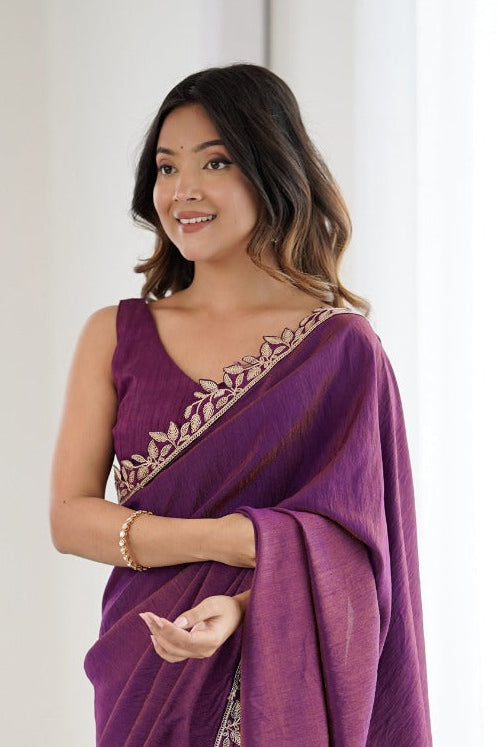 Woman wearing a purple saree with gold border in a bright room
