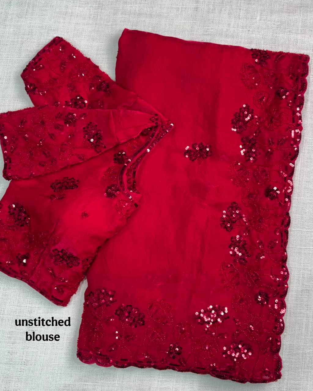 Red blouse with sequin details on a light gray background