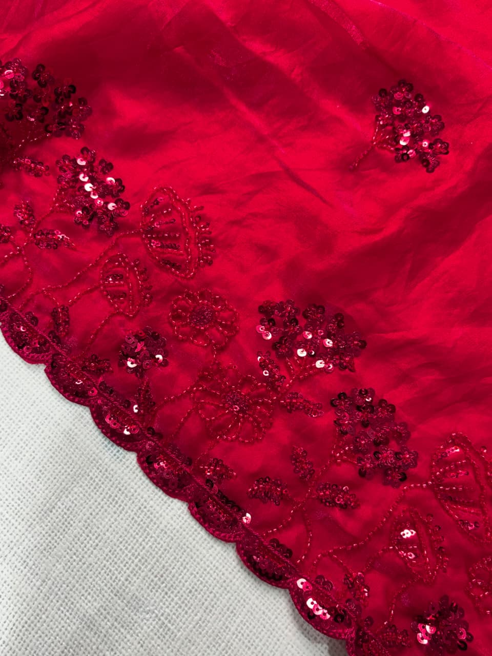 Close-up of red sequin fabric on a gray background