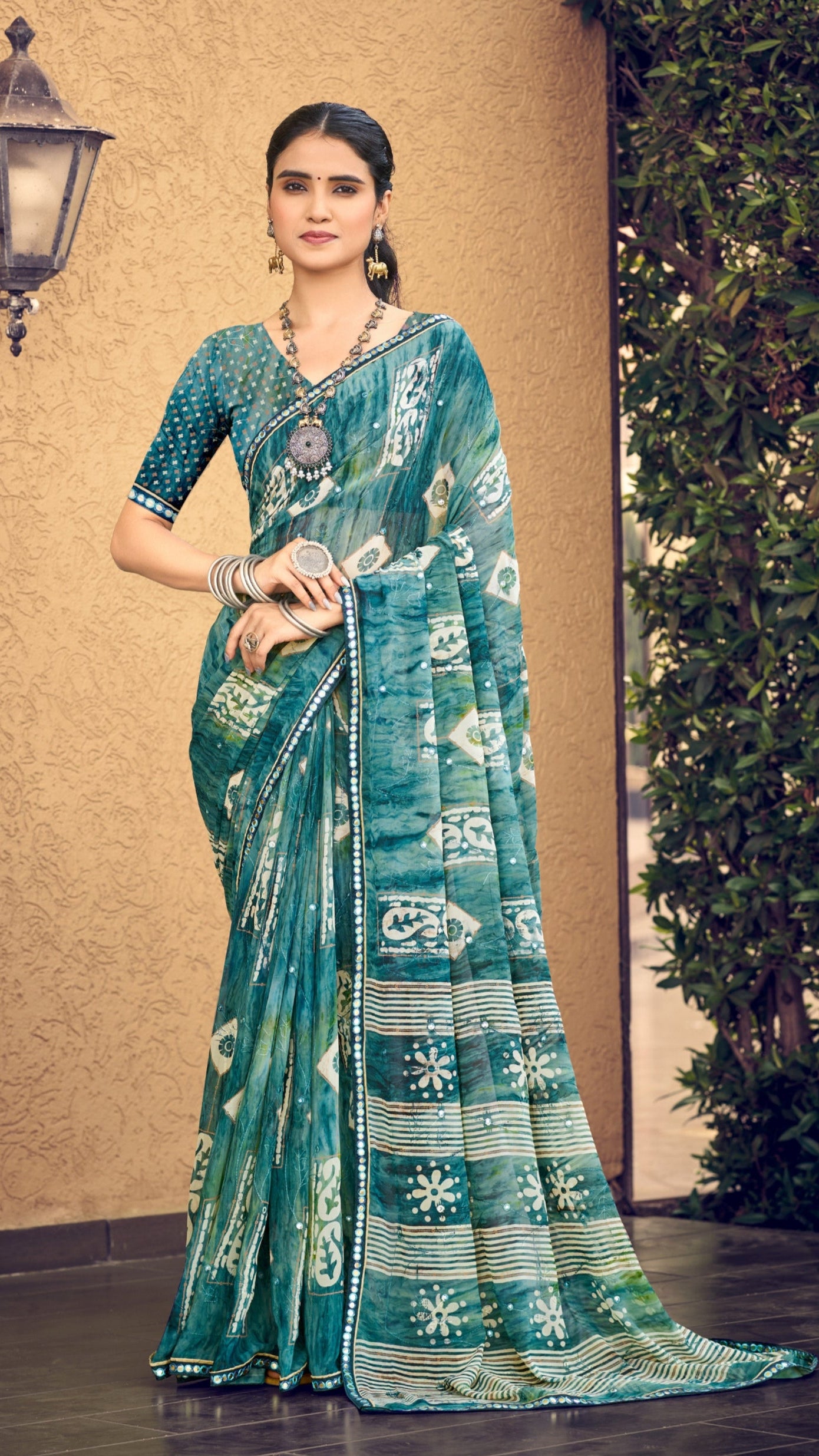 Teal green traditional printed synthetic silk saree with foil mirror work border